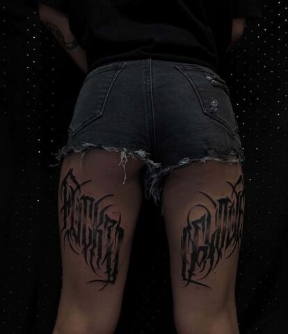 Para tatuaży napisowych w ostrym, gotyckim stylu na udach – tatuaż lettering Gniezno