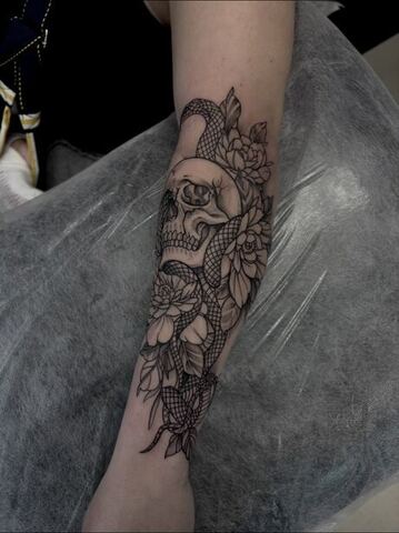 Tatuaż czaszki z wężem i kwiatami piwonii na przedramieniu – tatuaż blackwork Gniezno